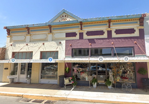 A two-story building with a storefront on the bottom and a balcony on the top.