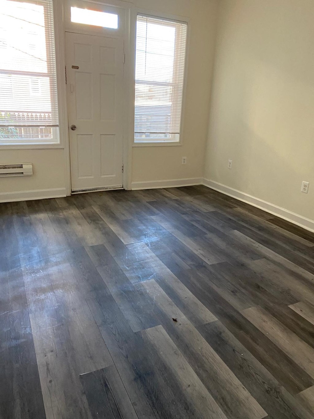 a living room with wood floors and a white door