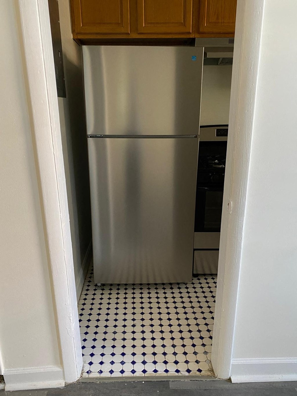 a stainless steel refrigerator in a small kitchen
