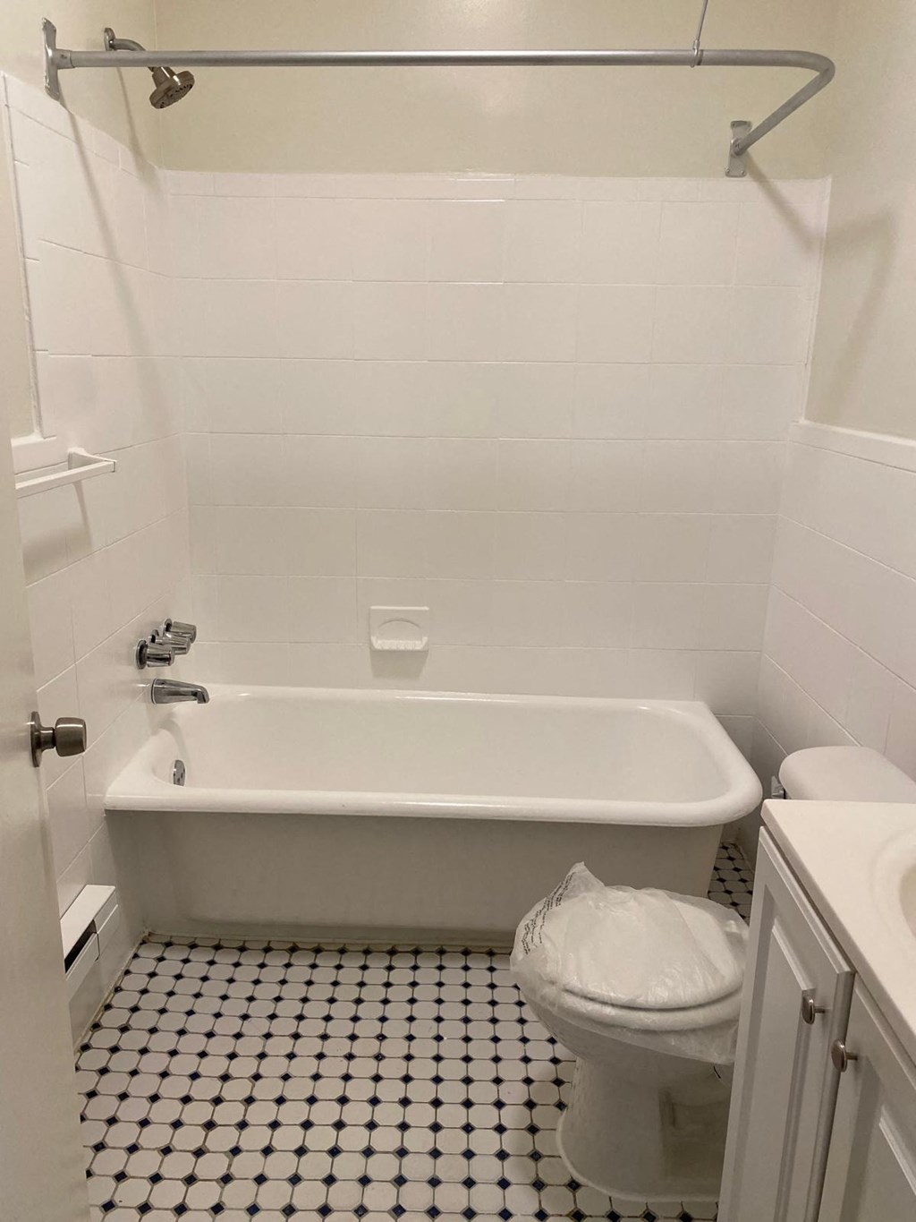 a white bathroom with a toilet and a bath tub