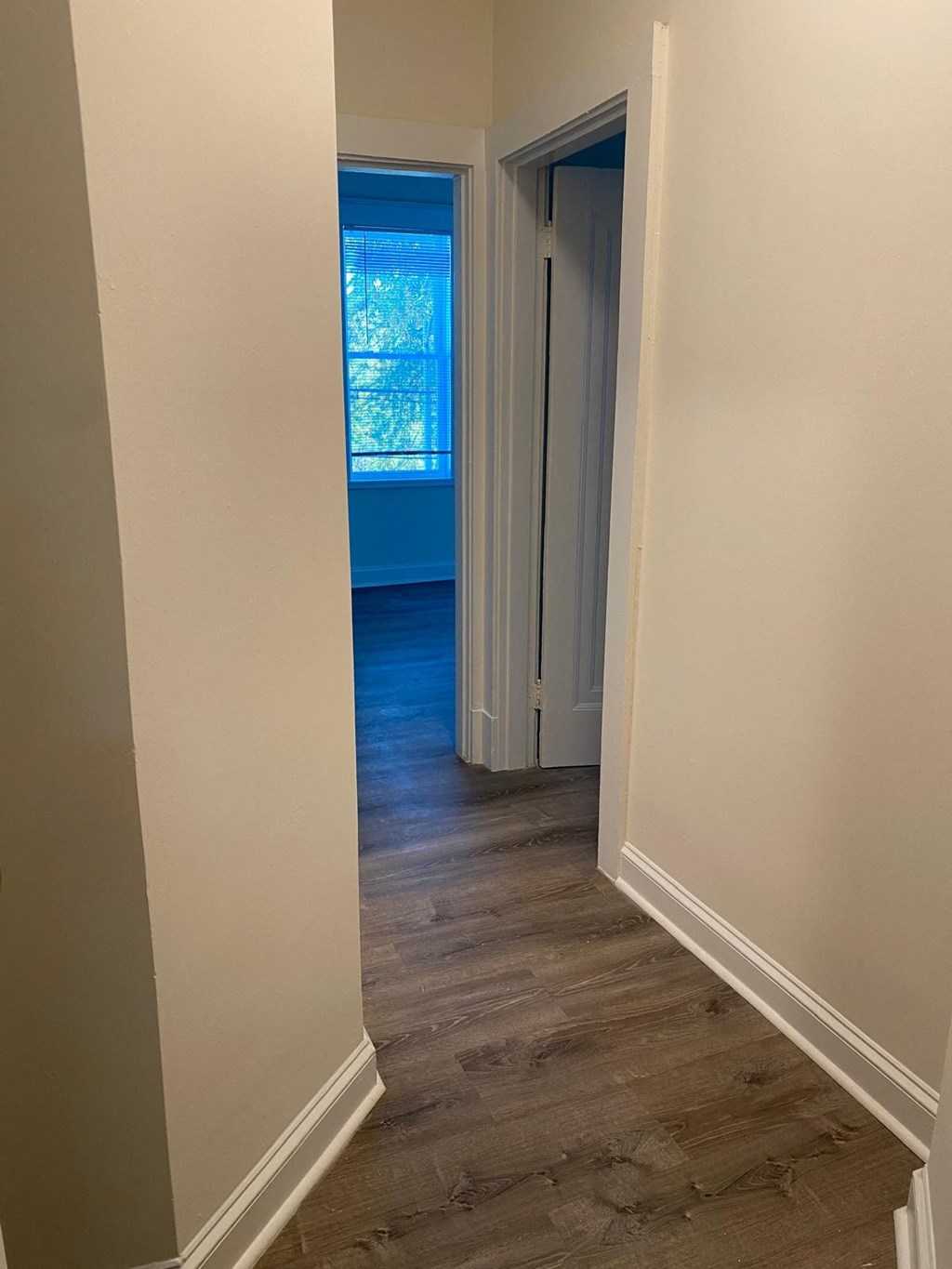 a hallway with a door to a bedroom and a window