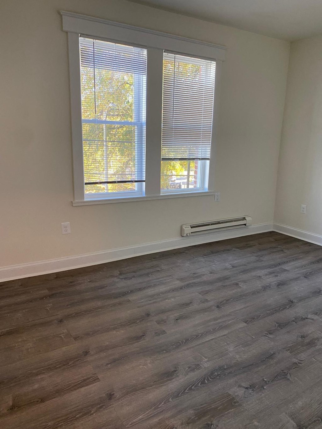 an empty room with wood floors and a window