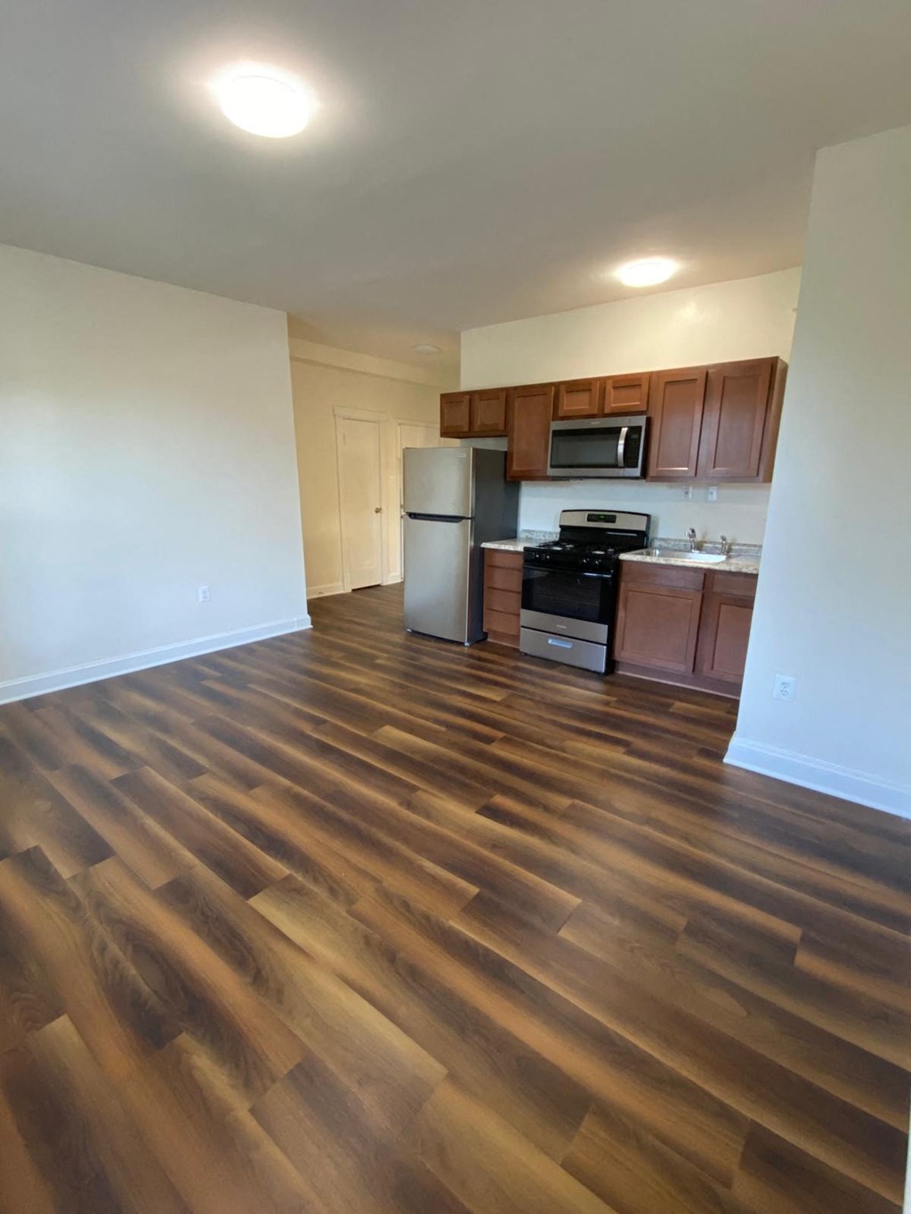 a kitchen and living room with a wooden floor