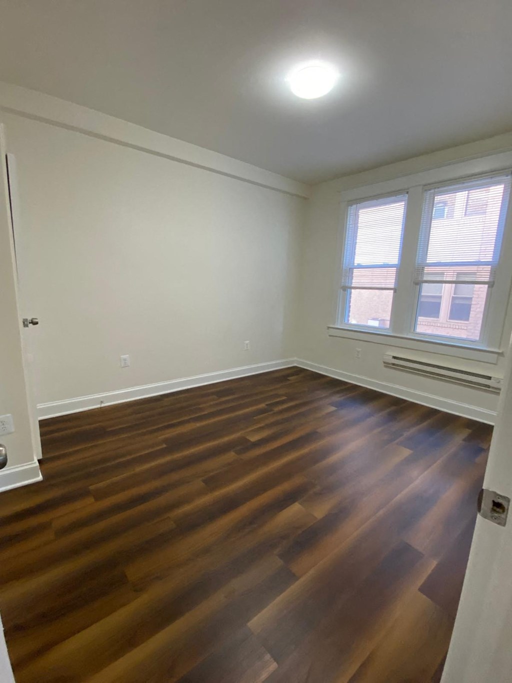 a living room with a hard wood floor and a window