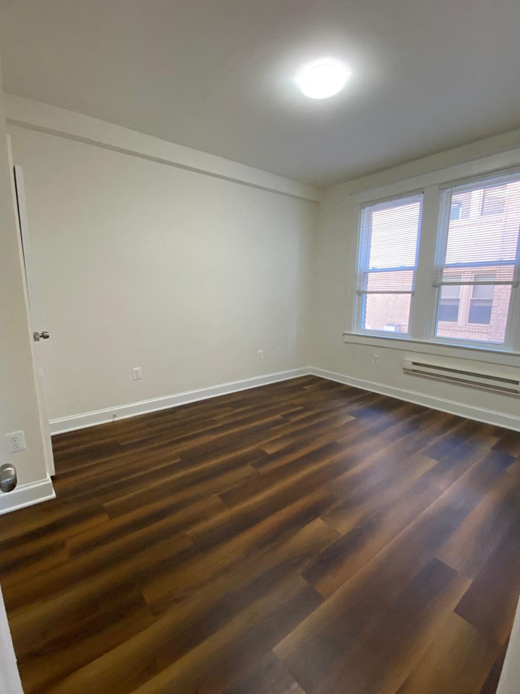the living room of an empty house with wooden floors