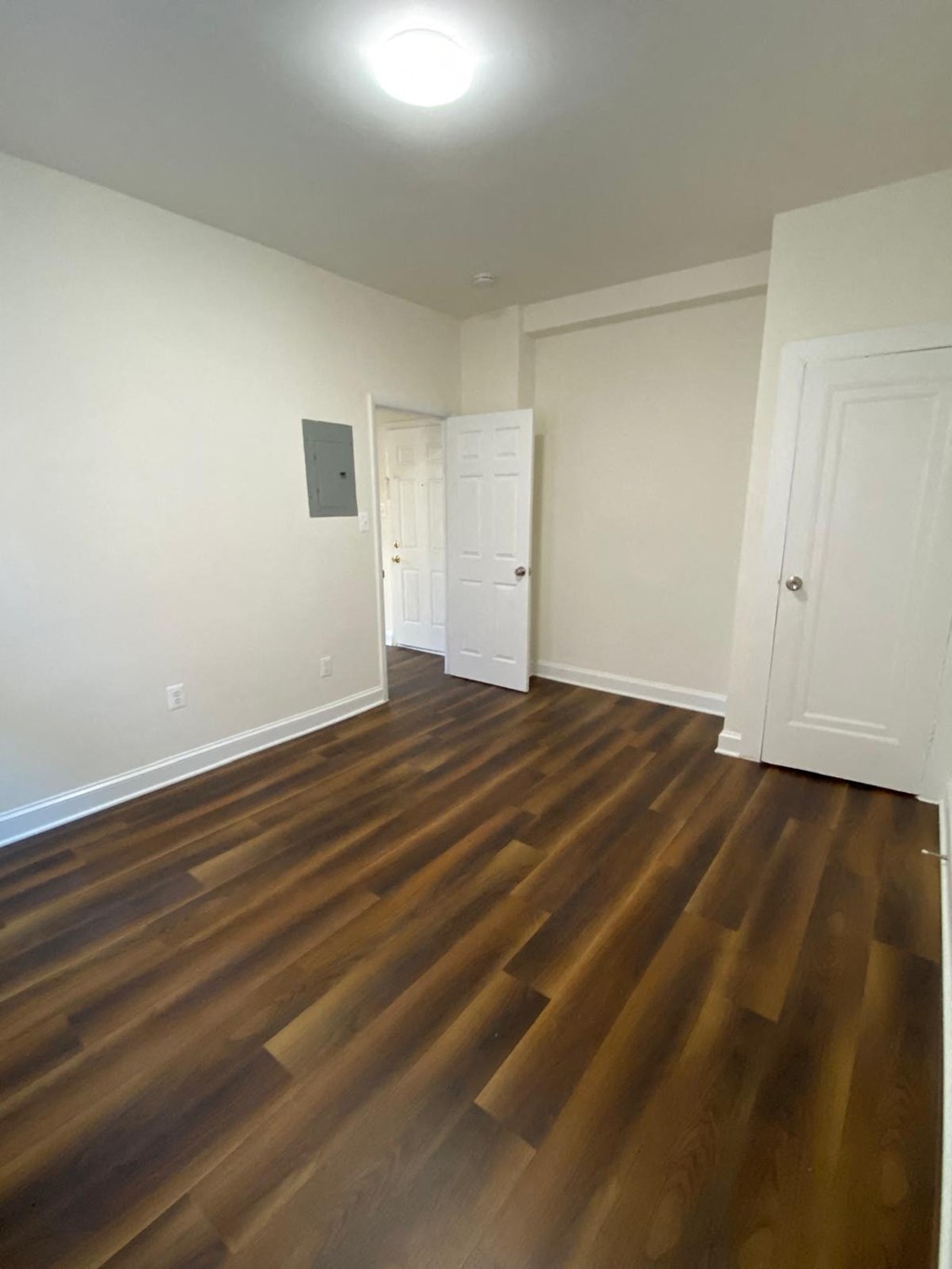 a living room with hard wood flooring and white walls