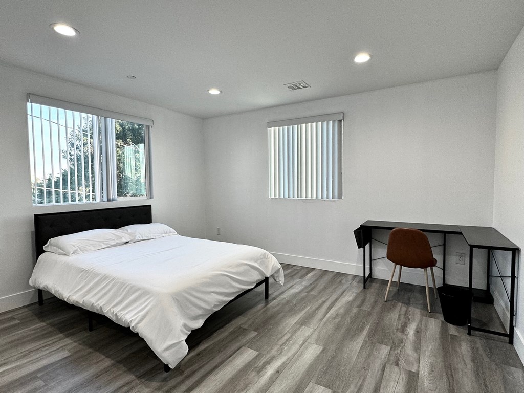 a bedroom with a bed and a desk with a chair