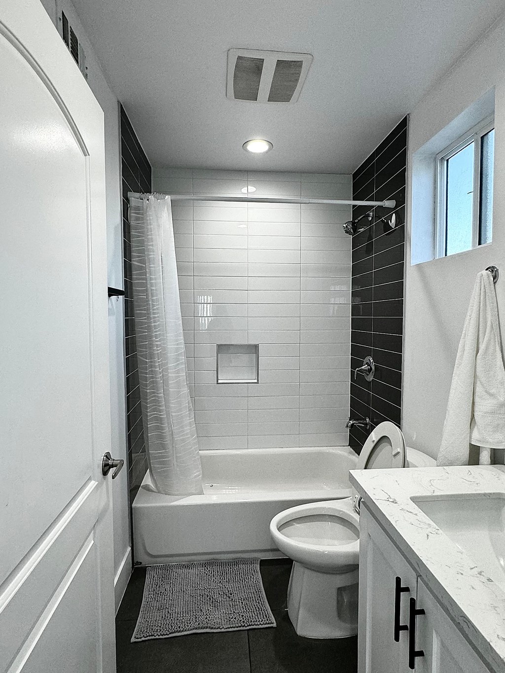 a bathroom with a toilet and a tub and a sink