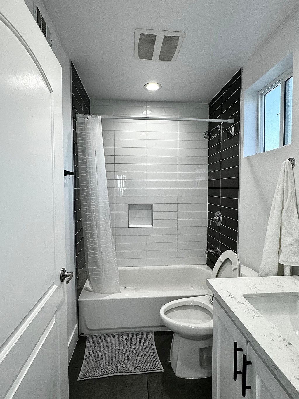 a bathroom with a toilet and a tub and a sink