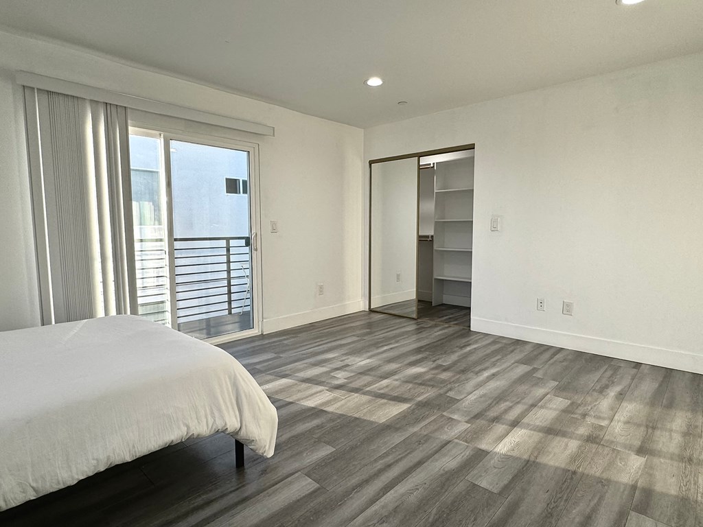 a bedroom with a bed and a sliding glass door