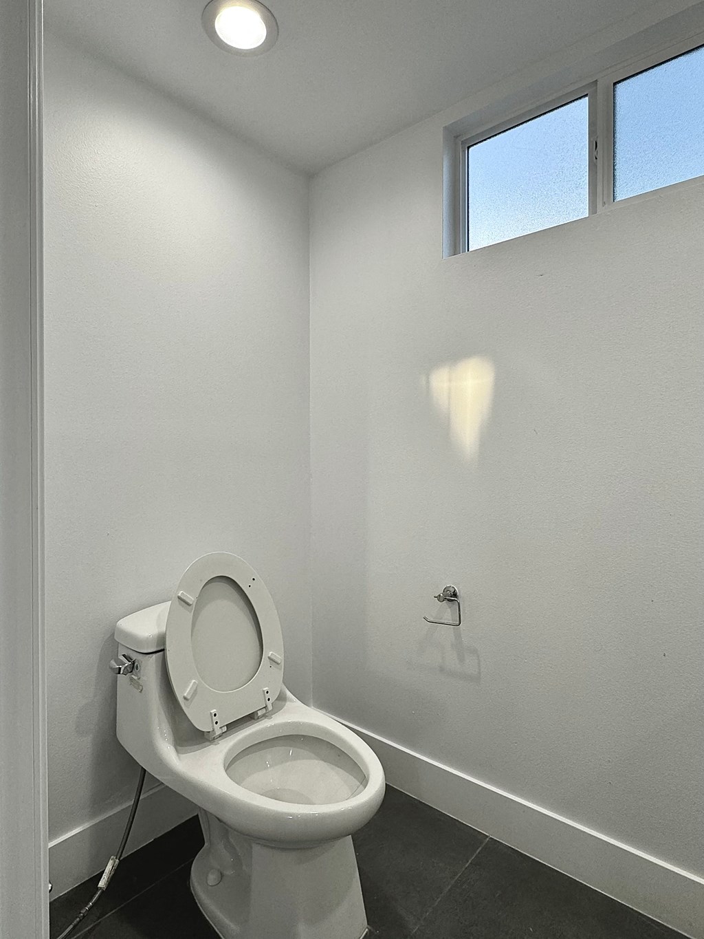 a bathroom with a toilet and a window
