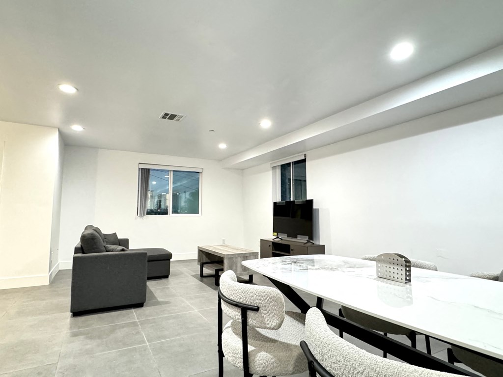 a living room with a table and chairs and a television