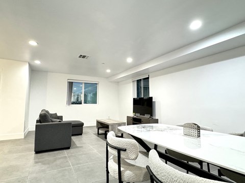 a living room with a table and chairs and a television