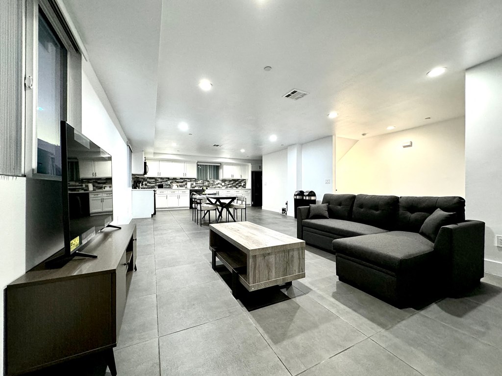 a large living room with black couches and a coffee table