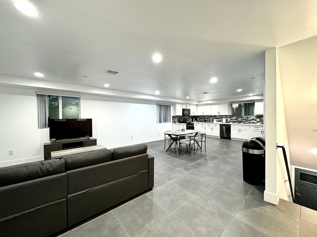 a living room and kitchen with a couch and a tv