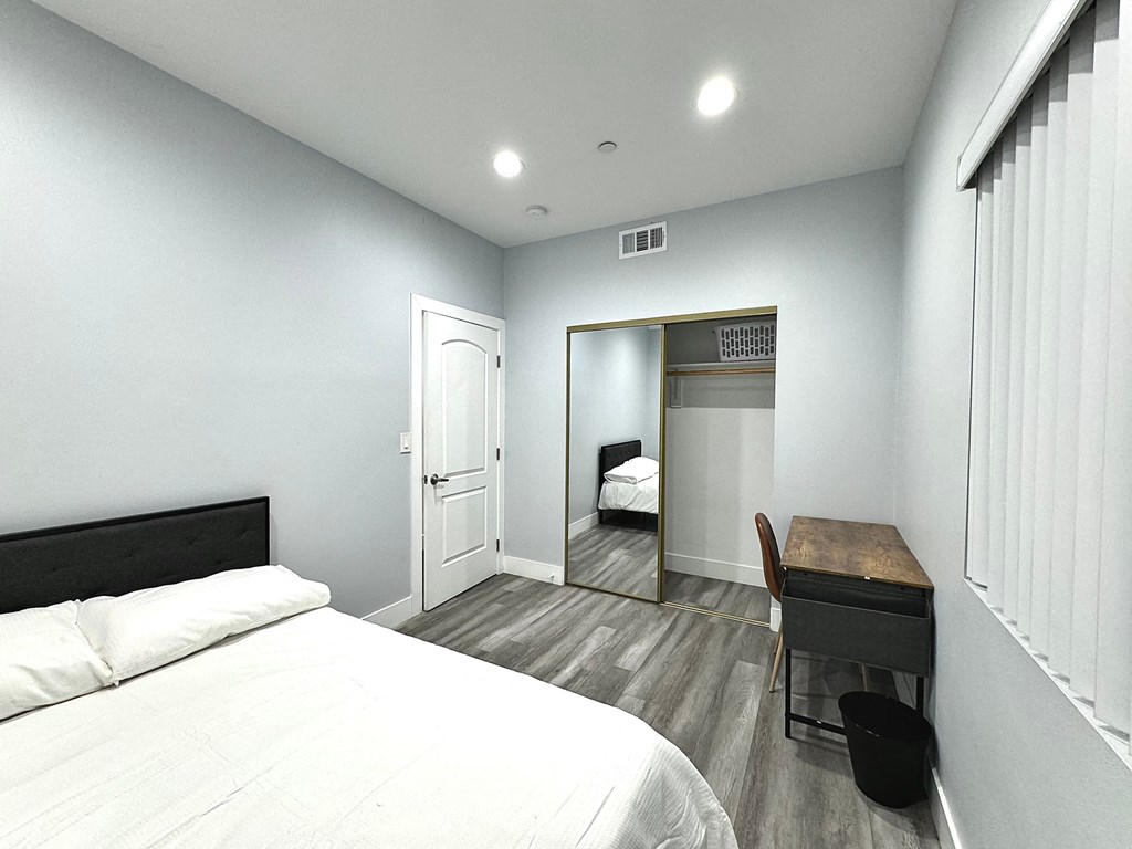 a bedroom with a bed and a desk