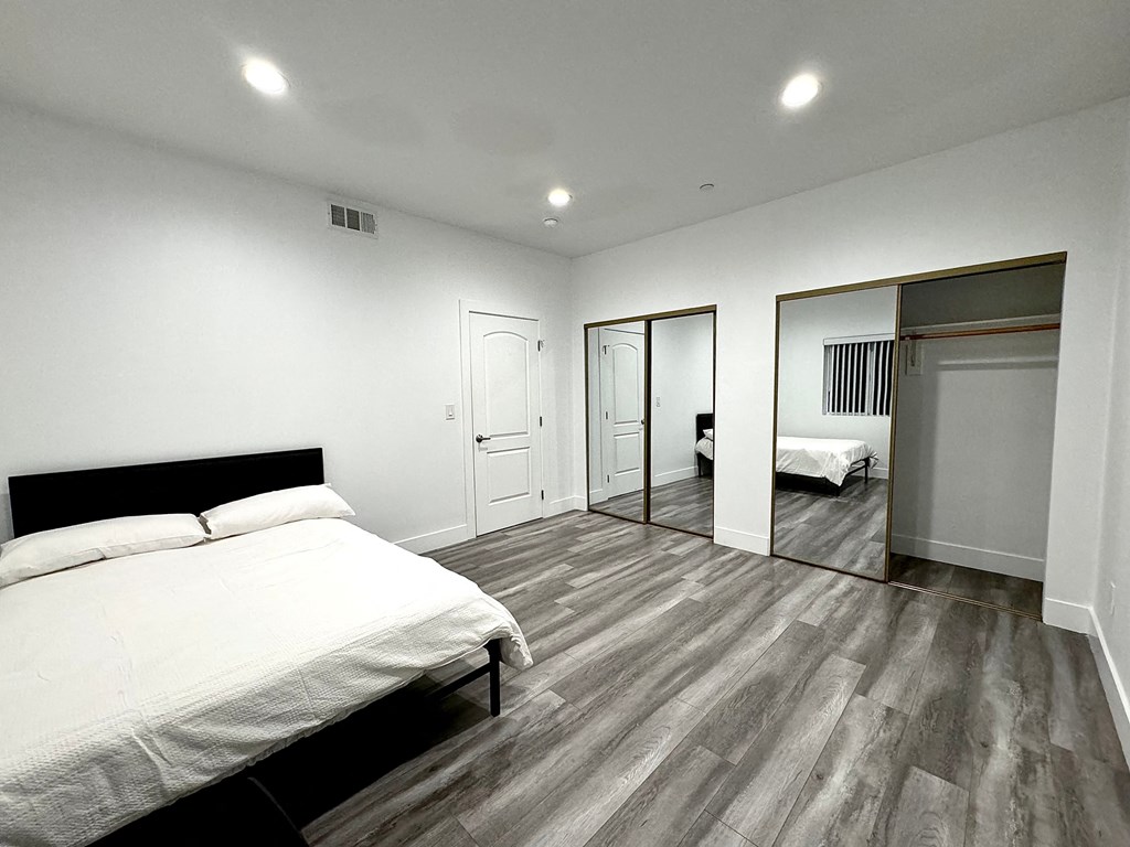 a bedroom with a bed and a mirrored closet