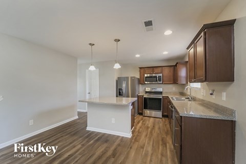 a kitchen with wood flooring and stainless steel appliances and