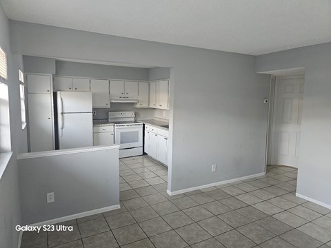 A kitchen with white appliances and cabinets.