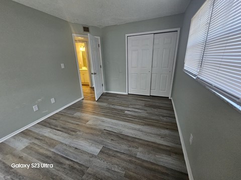 A room with a wooden floor and white doors.