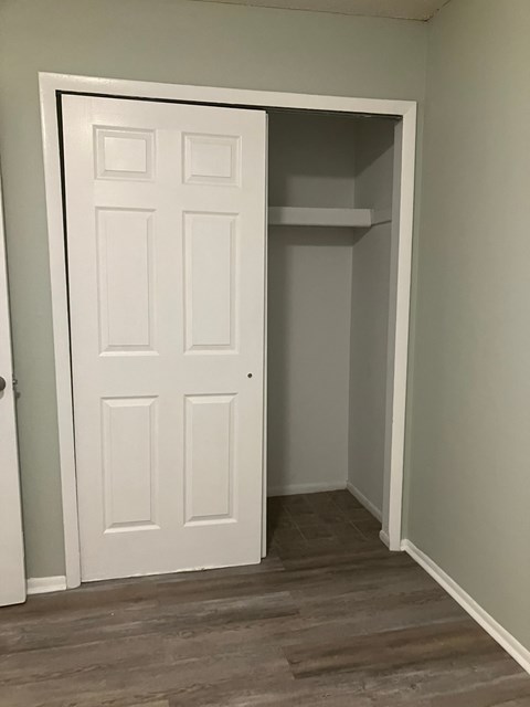 A white door is open to a small empty room.