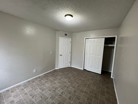 A room with two white doors and a tiled floor.