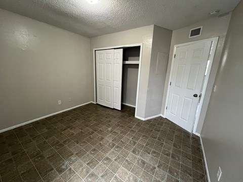 A room with a tiled floor and two white doors.