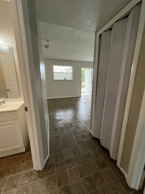 A bathroom with a white sink and brown tiles.