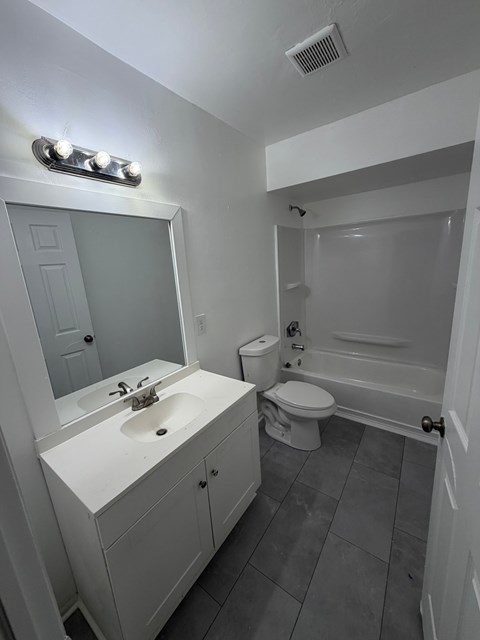 A bathroom with a white sink and a white toilet.