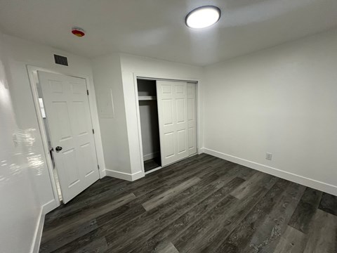 A room with a white door and a white wall with a light on the ceiling.