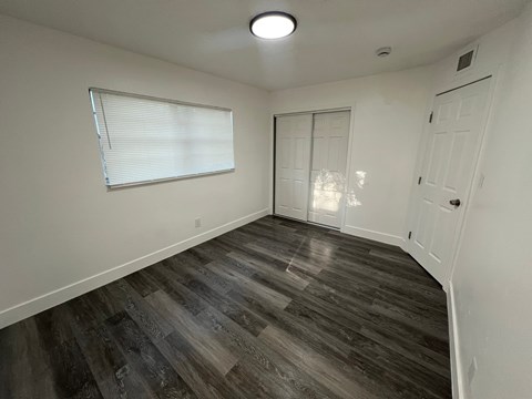 A room with a wooden floor and white walls.