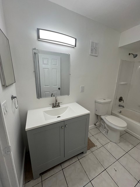 A white bathroom with a sink, toilet and bathtub.
