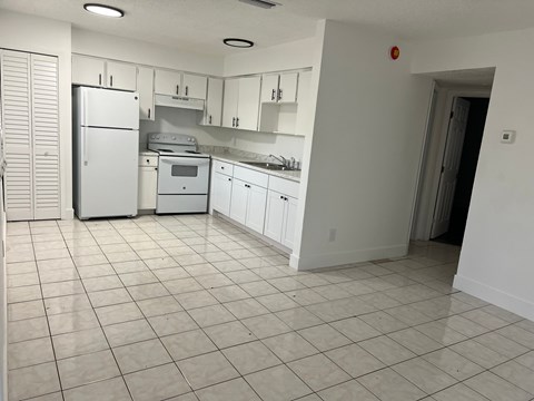 A kitchen with white appliances and cabinets.