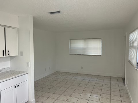 A kitchen with white cabinets and a countertop is shown.