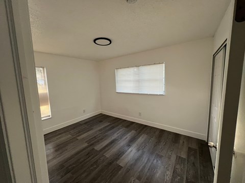A room with a window and wooden flooring.