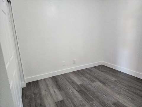 A room with a wooden floor and white walls.