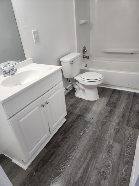 A white toilet sits next to a sink in a bathroom.