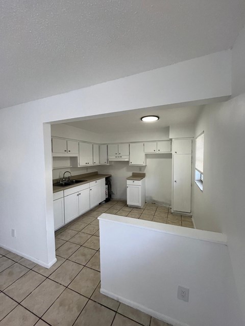 A kitchen with white cabinets and appliances.