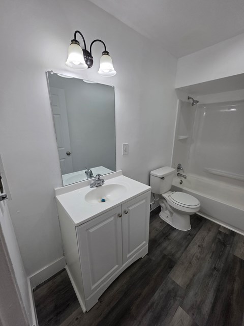 A white bathroom with a sink, toilet, and bathtub.