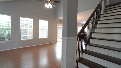 the view from the bottom of the stairs looking into the living room and dining room