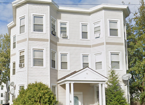 an apartment building with white siding and windows