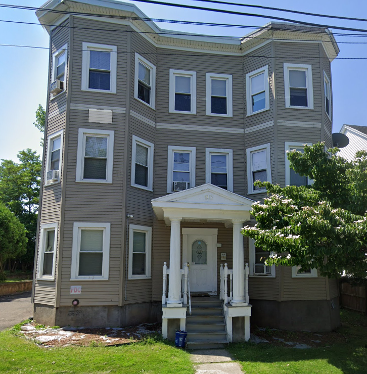 the front of a house with a white door and stairs