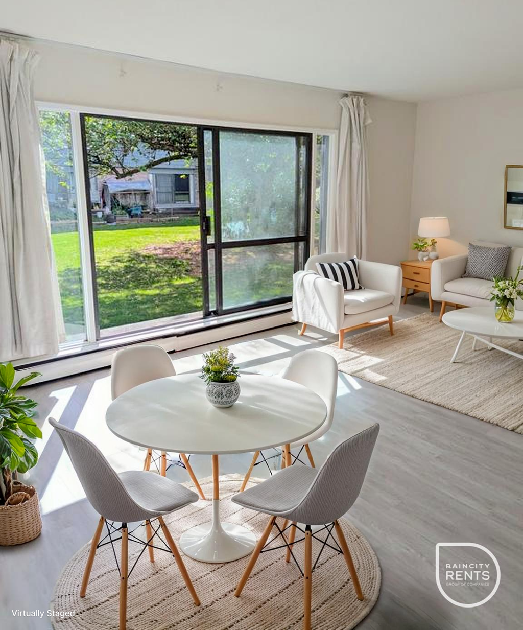 A living room with a white table and chairs, a lamp, and a plant.
