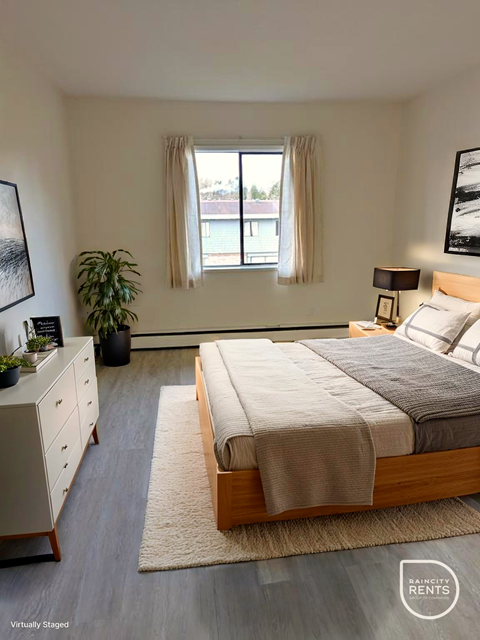 A bedroom with a bed, nightstand, and window.
