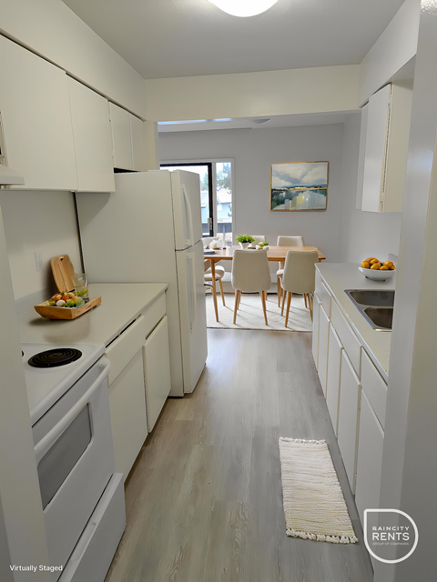 A kitchen with white appliances and cabinets.