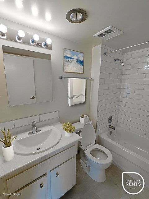 A bathroom with a white toilet, sink, and bathtub.