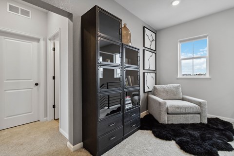 an armoire in a living room with a chair and