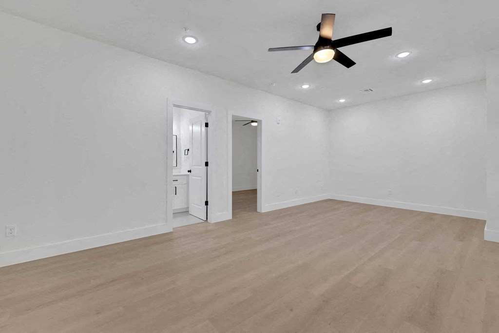 a living room with white walls and a ceiling fan