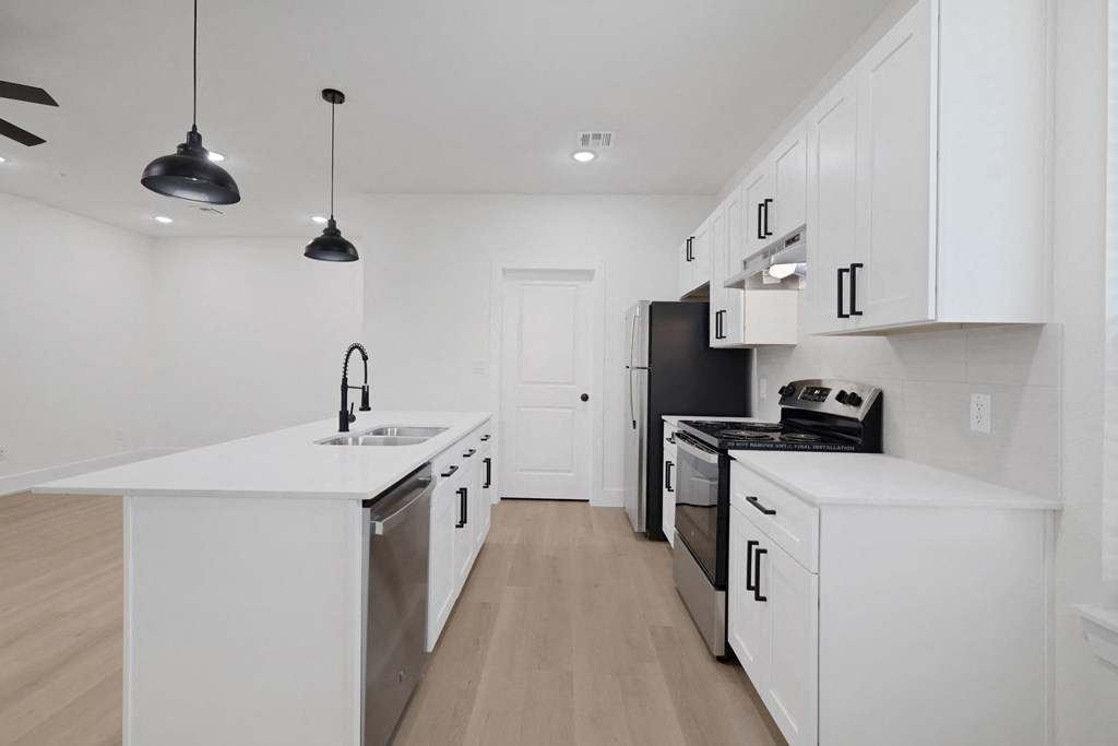 a renovated kitchen with white cabinets and stainless steel appliances