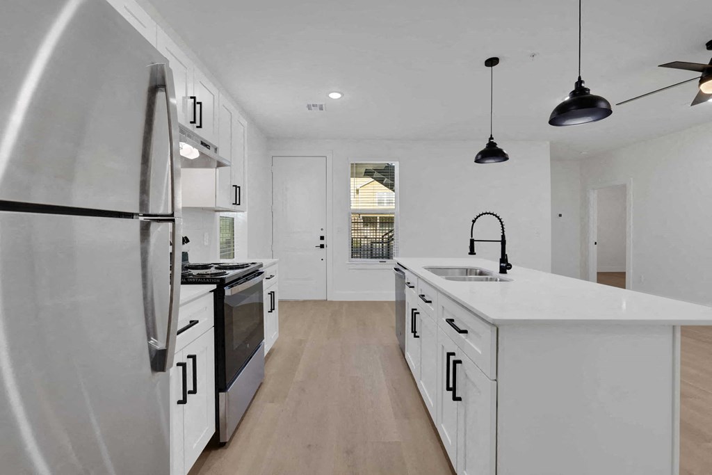 a white kitchen with an island and a refrigerator